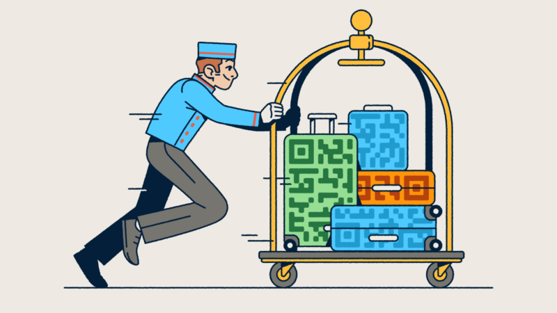 A bellhop pushing a luggage cart with several suitcases that have QR Code prints on them.